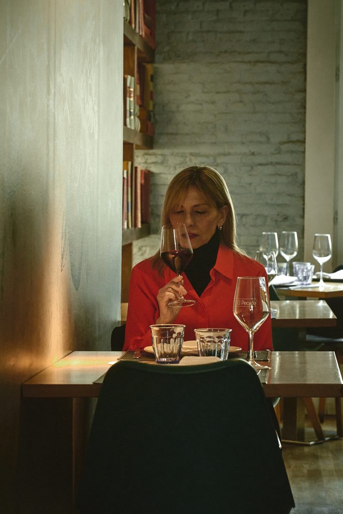 Carmen Burillo, responsable comunicación de El Pecado Restaurante en Salamanca, sentada en una de las mesas con matel del bonito comedor del primer piso